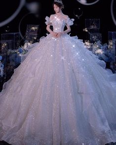 a white ball gown on display in front of blue and white decorations with bubbles around it