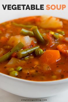 a white bowl filled with vegetable soup on top of a table