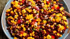 a bowl filled with beans and corn on top of a table