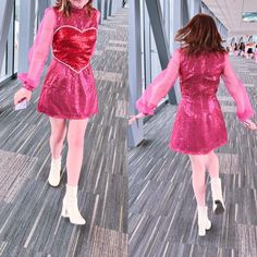 a woman in a pink dress walking across a wooden floor next to a metal structure