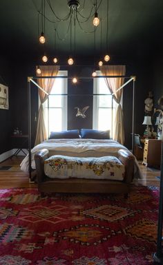 a bedroom with a large bed and lots of lights hanging from it's ceiling