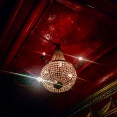 a chandelier hanging from the ceiling in a room with red walls and ceilings