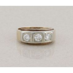 a three stone diamond ring on a white surface