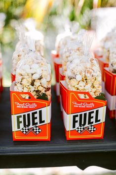 several bags of popcorn sitting on top of a black tray next to eachother