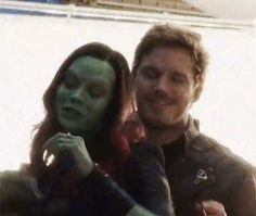 a man and woman with green paint on their faces are posing for a selfie