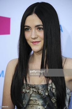 a young woman with long black hair posing for the camera at an awards ceremony in los