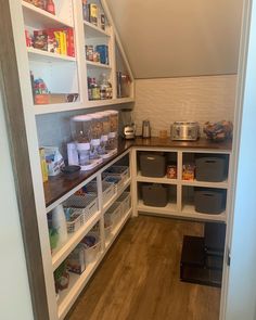 a pantry with lots of food and containers on the shelves, including plastic bins