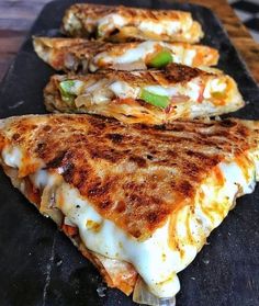 three quesadillas sitting on top of a cutting board next to each other