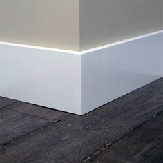 the corner of an empty room with wood flooring