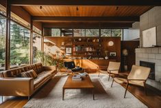 a living room filled with furniture and a fire place in front of a large window