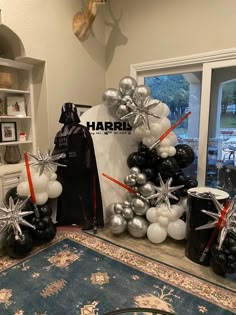 star wars themed balloons are on display in the living room with darth vader's costume