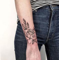 a woman's arm with a rose tattoo on it