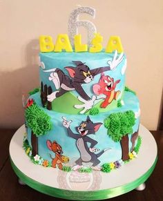 a blue and green cake with cartoon characters on it