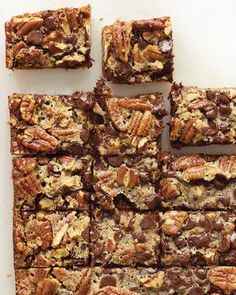 chocolate pecan bars cut into squares and stacked on top of each other with nuts