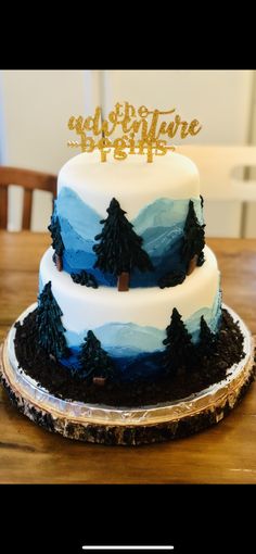 a three tiered cake decorated with trees and the words do not adventure begins on top