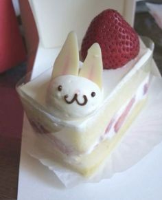 a piece of cake with strawberries in the shape of a bunny and a strawberry