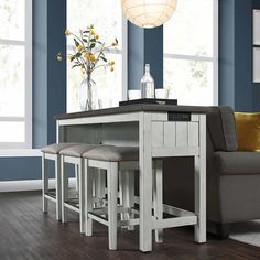 a kitchen table with stools in front of it and a vase filled with flowers