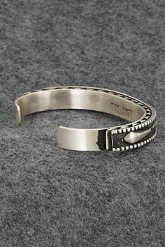 This sterling silver bracelet was made by Navajo silversmith Leander Tahe. The inside is signed L. Tahe and stamped sterling.Size: 5 3/4" (will fit up to a 7 1/8" wrist)Gap: 1 3/8"Width: 3/8"Free shipping on all orders! We ship with USPS and always include tracking. All orders ship within a day of payment.Returns are accepted up to 30 days after you receive your order. Just send us a message. Our shop offers cash back or store credit. The item must be returned in new condition. Southwestern Sterling Silver Polished Bangle Bracelet, Southwestern Sterling Silver Bangle With Polished Finish, Southwestern Polished Sterling Silver Bangle, Sterling Silver Southwestern Bracelet With Polished Finish, Oxidized Sterling Silver Southwestern Bracelet, Oxidized Finish Southwestern Sterling Silver Bracelet, Sterling Silver Bracelet, Native American Jewelry, Free Jewelry