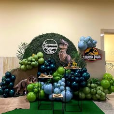 balloons and decorations are displayed in front of a dinosaur backdrop at the entrance to an office building