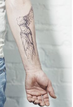 a person with a tattoo on their arm holding the hand of another person's wrist