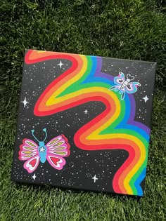 a painting on the grass with butterflies and rainbows