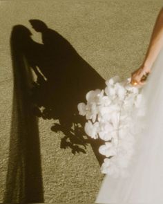 the shadow of a person holding a bouquet of flowers