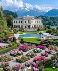 a large white house surrounded by lush green trees and flowers in front of a pool