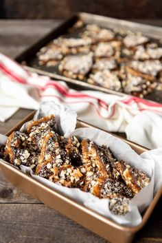 two trays filled with chocolate covered pretzels on top of a wooden table