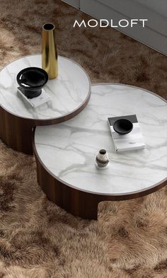 two coffee tables with marble top sitting on a shaggy carpeted floor next to each other