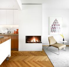 a living room with a fire place next to a counter top and a chair in front of it