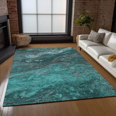 a living room filled with furniture and a large rug on top of a hard wood floor