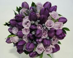 a bouquet of purple flowers in a clear vase