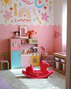 a child's room with pink walls and toys