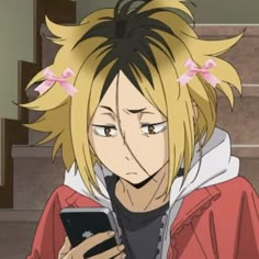 an anime character holding a cell phone in her hand and looking at the screen while wearing a red jacket