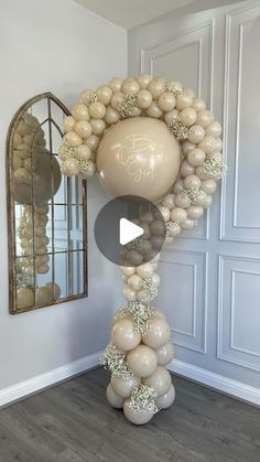 balloons are arranged in the shape of a wreath on top of a table with a mirror behind it