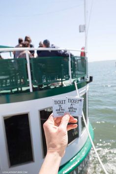 a person holding up a ticket for a boat ride