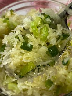 sauerkraut salad in a glass bowl with a spoon on it and the words sauerkraut above it