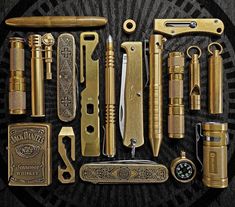 an assortment of different types of knives and other items on a black background with gold accents