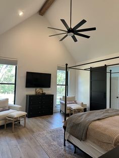 a bedroom with a bed, chair and ceiling fan in it's center area