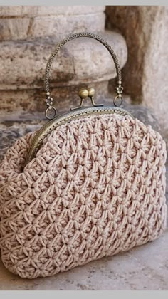 a crocheted purse sitting on top of a stone slab