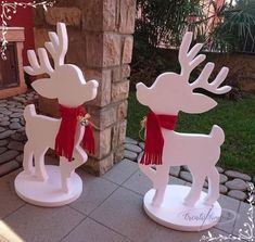 two white wooden reindeer statues with red scarfs