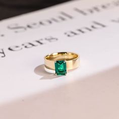 an emerald ring sits on top of a book