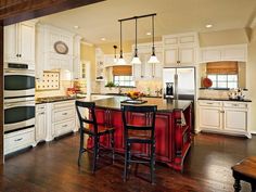 a large kitchen with white cabinets and black counter tops, an island in the middle