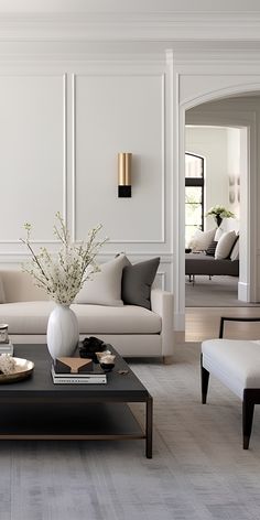 a living room filled with furniture and a large white vase on top of a coffee table