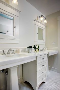 a white bathroom with two sinks and mirrors