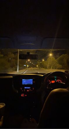 the interior of a car at night with its lights on and dashboard illuminated by streetlights