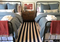 two beds in a bedroom with striped rugs