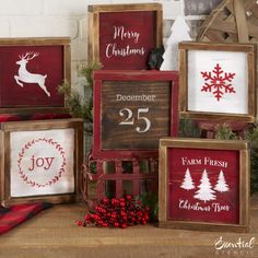 christmas signs are displayed in wooden frames on a table