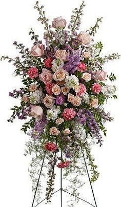 a large arrangement of flowers on a stand in front of a white background for display