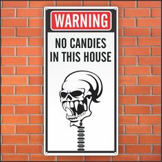 a sign on a brick wall warning people not to block the drive way with a skull